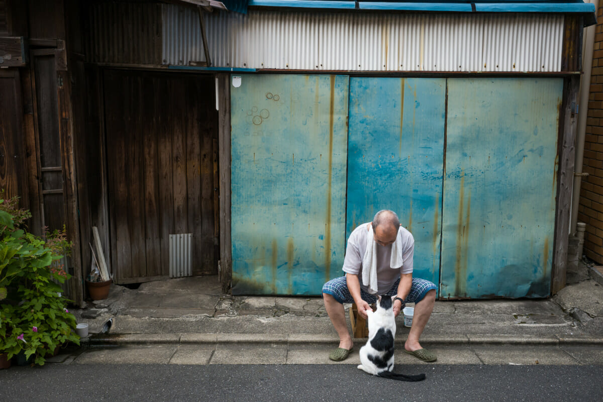 a Japanese man and his cat in an old Tokyo neighbourhood