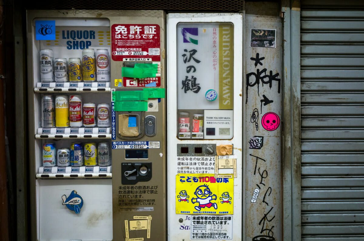 broken and taped up Japanese booze vending machines