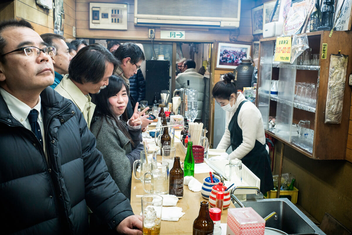 Japanese woman in a jam-packed Tokyo standing bar