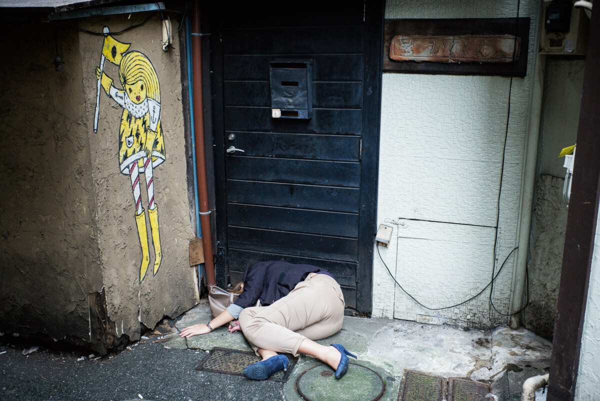 Japanese woman passed out drunk in a dirty Tokyo alleyway